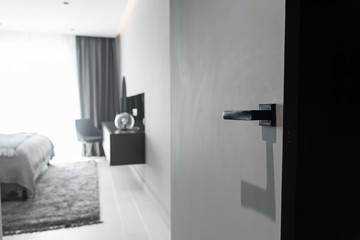 Modern black door handle and lock on black wooden hidden door. Close-up elements of the modern interior of the apartment.