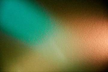 On a textural, partially blurred background, a combination of dark green cream and turquoise