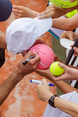 Tennis player signs autograph after win