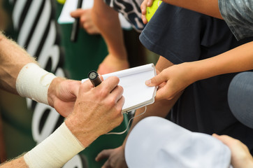 Tennis player signs autograph after win