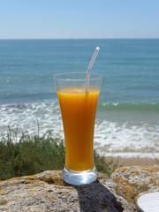 Orange juice, a refreshing, vitamin-rich drink, on the beach overlooking the sea
