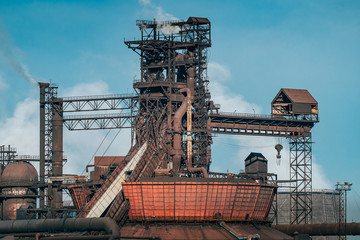 Fototapeta na wymiar Iron tower constructions and pipes with smog of metallurgical plant as industrial background. Pollution from heavy industry