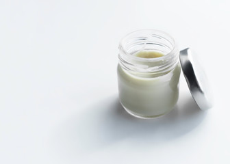 glass jar with cosmetic cream on a light background. copy space