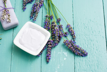 Obraz na płótnie Canvas lavender soaps and cosmetic cream, flowers on blue wooden table