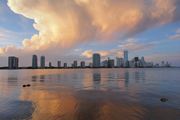 A very colorful cloudscape over the City of Miami skyline reflected on the calm waters of Biscayne Bay, Florida.