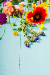 herbal and wildflowers on blue wooden table background