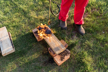 A man burns wooden planks with propane using old-time Japanese technology, creating facing material for building a house