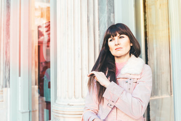 Portrait of a Stylish Pretty Young Woman in Autumn Fashion walking the city, near the window shop