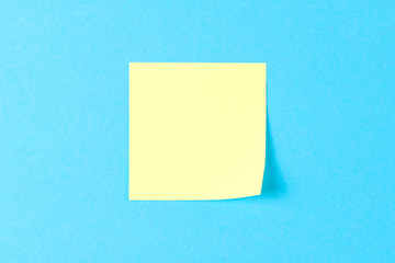 Blank yellow sticker on a blue background, business work concept. Yellow commemorative stickers on the blue wall. Mock-up