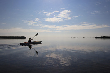 Kayaker enjoying a very calm early morning paddle on Biscayne Bay in Biscayne National Park, Florida