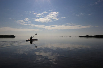 Kayaker enjoying a very calm early morning paddle on Biscayne Bay in Biscayne National Park, Florida