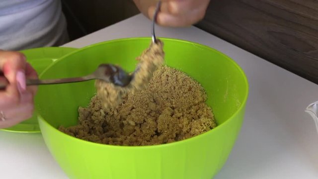 A woman mixes a cookie crumb with condensed milk. Cooking basics for cake pops.