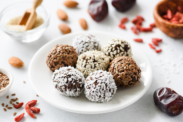 Fototapeta na wymiar Healthy vegan protein energy balls with nuts, seeds and dried fruits. Homemade raw chocolate truffles