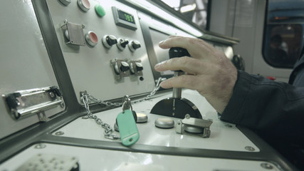Interior view of the drivers cab high speed train. Train driver hand on thrust lever of dashboard controls in cockpit cabin.