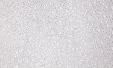 A textured surface of bubbles on a plastic transparent sheet, different sizes, white pseudo-random pattern.