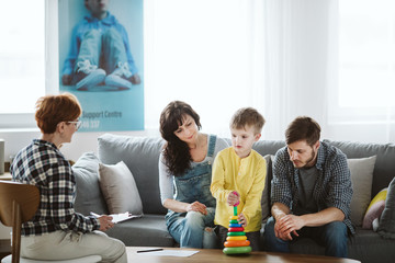 Parents and therapist are sitting on the couch during a meeting about their child