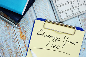 Change your life- motivation quote handwritten on a piece of paper.