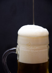 in a glass of beer beer and shrimps the scattered salt and a lemon a rcherny background pour, selective focus