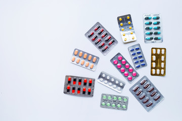 Various capsule medicines, pills and tablets in blister pack on white