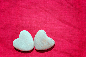 two hearts on red fabric background