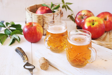 Two cups of Apple Cider and red apples
