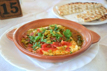 Greek lunch. Feta cheese baked with tomatoes and sprinkled with a chopped parsley. Dish served with pita bread