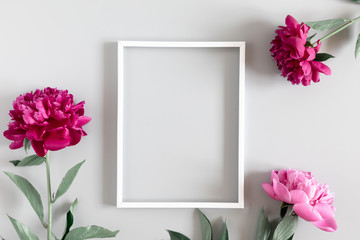 Beautiful flowers composition. Blank frame for text, red peonies flowers on gray background. Flat lay, top view, copy space