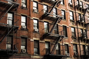 Close-up view of New York City style apartment buildings with emergency stairs along Mott Street in Chinatown neighborhood of Manhattan, New York, United States. - obrazy, fototapety, plakaty