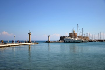 The entrance to the historic Mandraki Harbour. deer and doe statues and the Fort of St Nicholas at the entrance to Mandraki Harbour.  