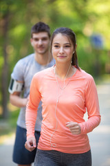 Young couple jogging together in park