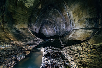 Urban sewage flowing through large oviform underground turning sewer tunnel