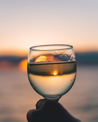 glass of wine on the beach at sunset