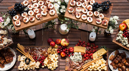 Top view of wooden table full of various food - meat, cheese, bread, fruit. Organic food and restaurant concept with decoration.