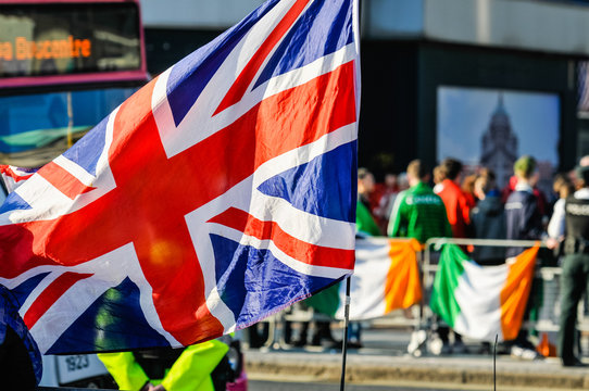 Belfast, Northern Ireland, UK. 17 Mar 2016. Nationalist youths hold up tricolours, some with "IRA" written on them, in an attempt to provoke Loyalist Union Flag Protesters.