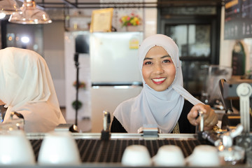 Fototapeta na wymiar young muslim barista woman making coffee with beauty face