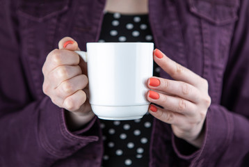 A woman holding white mug