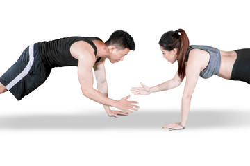 Sporty couple clap hands during push up on studio