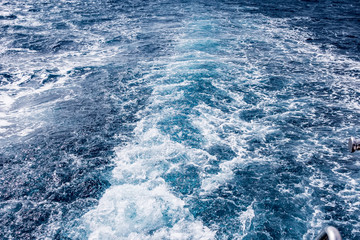 Cruise ship wake Wave ocean trace on blue sea water background.