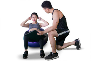 Fototapeta na wymiar Trainer teaches his client to sit up exercise