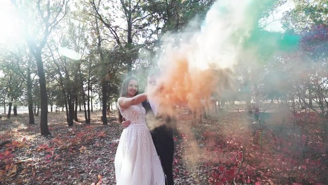 Romantic wedding moment, couple of bride and groom using hand flare or fusee smoke . Loving wedding couple outdoor.
