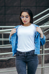 Fototapeta premium Girl wearing t-shirt with place for logo, posing against street