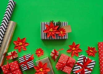 Fototapeta premium The process of packaging Christmas gifts. Poinsettia. New Year.