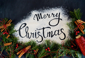 New Year's decor, located in a circle on a black wooden background, in the middle of the inscription