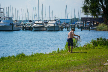 Fototapeta premium Man that Hand Launches the Fishnet at Sea