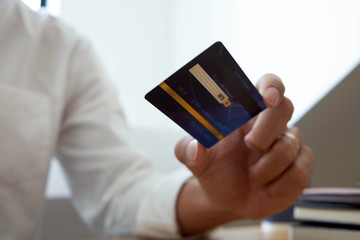 Using a credit card to pay online, use a smartphone for online shopping, a male hand holds a credit card.