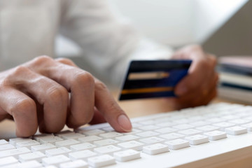 Using a credit card to pay online, use a smartphone for online shopping, a male hand holds a credit card.