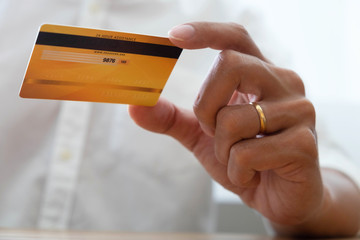 Using a credit card to pay online, use a smartphone for online shopping, a male hand holds a credit card.