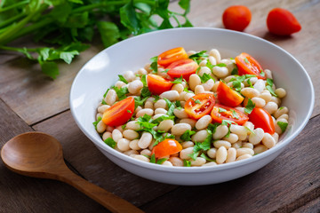 White bean salad with cherry tomatoes and parsley in bowl
