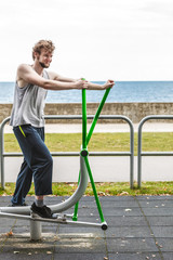 Fototapeta na wymiar Active man exercising on elliptical trainer.