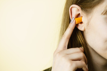 Woman putting ear plugs into ears
